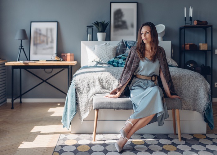 Femme élégante dans une chambre moderne bleue démontrant une décoration de chambre d'un adulte sophistiquée et harmonieuse