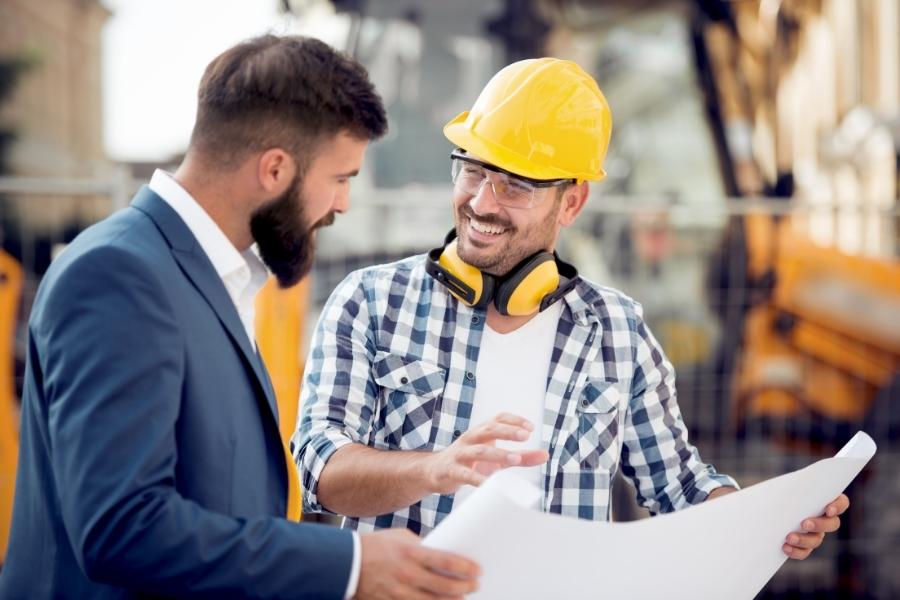 Des professionnels de la construction discutent des plans sur un chantier.