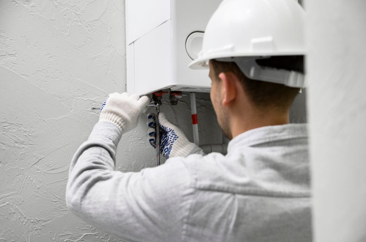 Un chauffagiste professionnel en casque de chantier intervient sur une installation pour évaluer le prix entretien annuel chaudière gaz.